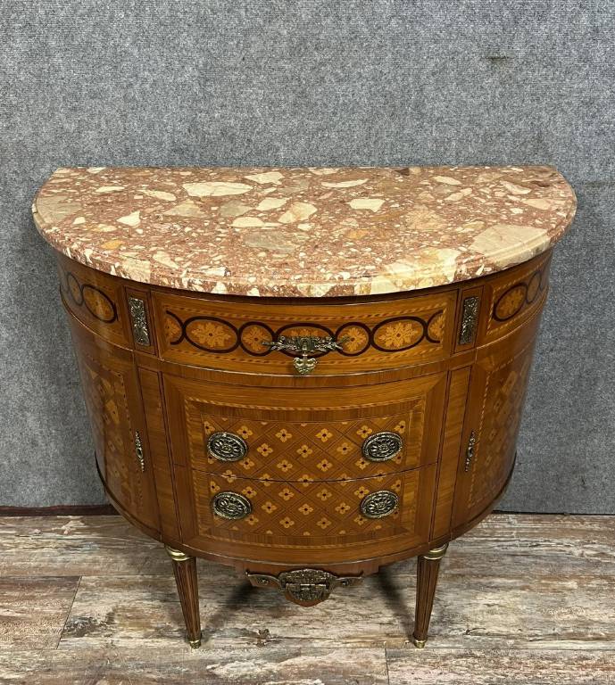 Commode demi-lune de style Louis XVI en placage de palissandre et bois de rose, marqueterie de fleurs et frisages. | Puces Privées