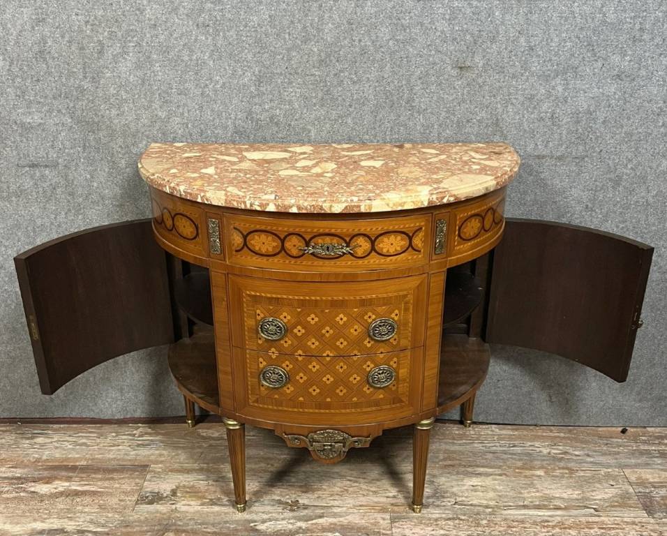 Commode demi-lune de style Louis XVI en placage de palissandre et bois de rose, marqueterie de fleurs et frisages. | Puces Privées